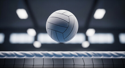 A volleyball hovering over a net in a dimly lit gymnasium with blurred lights in the background