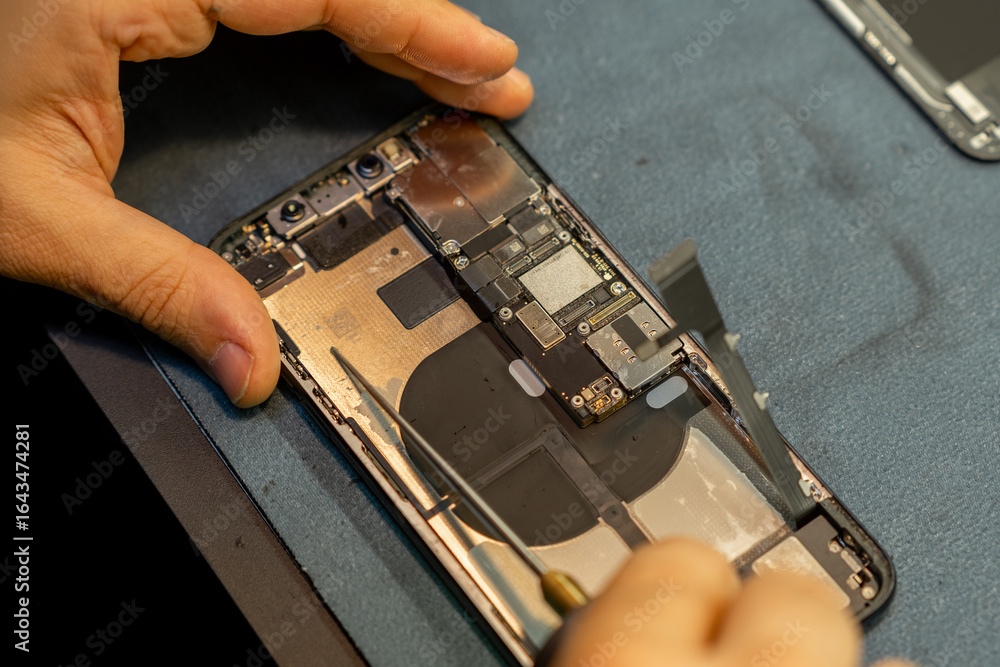 Poster expert phone repair technician working on smartphone internals in a workshop environment to fix hard
