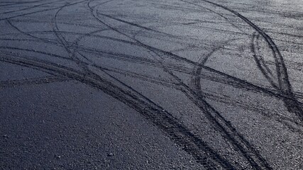 Clear tire tracks are visible on the asphalt, creating an interesting pattern symbolizing the movement and dynamics of urban life.