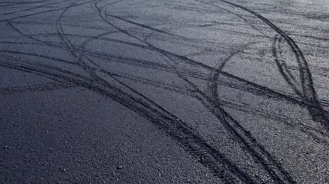 Clear tire tracks are visible on the asphalt, creating an interesting pattern symbolizing the movement and dynamics of urban life.