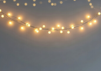 Soft warm glow of decorative string lights on a gray background