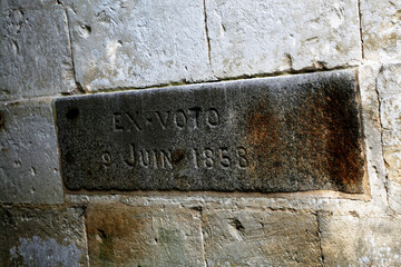 Historical inscription located on a weathered stone wall from 1858 in an old building