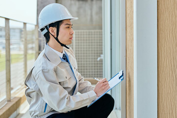 建物を確認する作業服姿の男性