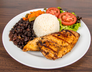 Grilled chicken breast with rice, black beans, and fresh vegetables on a white plate. Generative AI