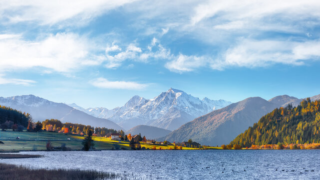 Gorgeous autumn view of Haidersee (Lago della Muta) lake with Ortler peak on background.