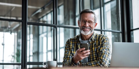 The smiling senior man enjoying technology in a modern office space.