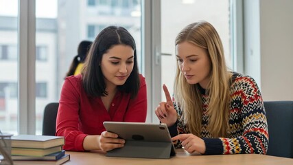 Two young women looking at a tablet computer together - Powered by Adobe