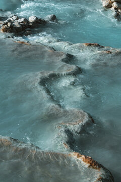 View of cascading turquoise waters flow over terraced travertine rocks, creating a mesmerizing, natural spa experience, Saturnia, Tuscany, Italy.