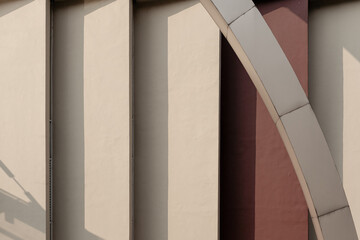 Obraz premium Minimalist abstract photo of modern architecture, showing a play of light and shadow on geometric pillars and a diagonal arch.