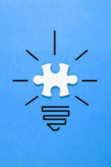 puzzle pieces as light bulb on a yellow background