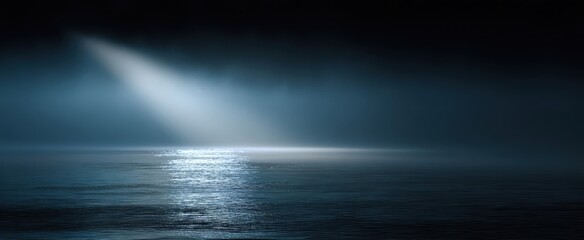The serene ocean illuminated by a mystical beam of light at night.