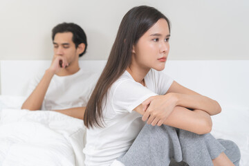 Angry, depressed, frustrated asian couple quarrel, fighting on bed in conflict, divorce or...