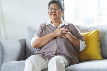 Chest pain, attack chest, emergency heartbeat asian senior woman holding hand on chest, suffering...