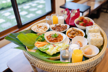 Traditional Japanese style meal served on woven tray with various dishes and drinks reflecting...