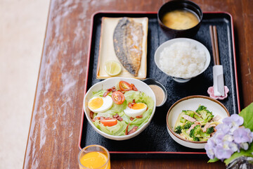 Japanese style traditional meal with rice grilled fish salad and miso soup reflects culture and offers healthy balanced dining experience with fresh ingredients and presentation