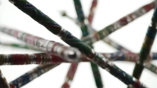 Slow-motion shot of colorful dandiya sticks crossing in mid-air, pure white background