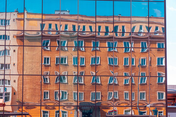 Reflection of an old building in the windows of a modern art