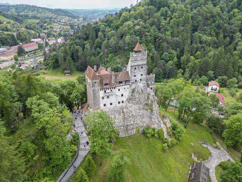 Aerial view of Bran Castle surrounded by lush greenery and scenic mountains, Bran, Brasov, Romania.
