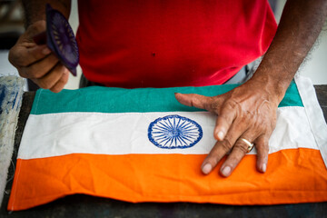 A worker stamp Ashoka Chakra on Indian national flag in a manufacturing unit