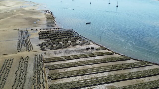 Ria Formosa riverbed at low tide, with shellfish production and yachts anchored in the river in Algarve, Portugal