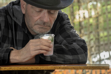 Middle-aged bearded man drinking an alcoholic beverage