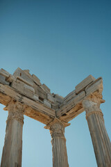 Low angle view of ancient stone ruins with columns against a clear blue sky on a bright sunny day