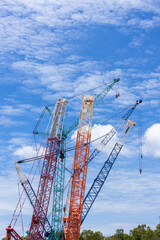 Crawler crane on blue sky white clouds background, Real estate industry. Red crawler crane use reel lift up equipment in construction site. Crane for rent. Crane dealership for construction business.