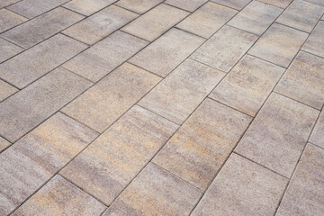 Stone sidewalk in a public place. Detail of a town square. Light beige tile, architectural background