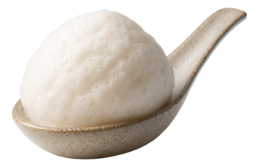 A light, airy scoop of coconut foam sitting on a textured ceramic spoon.
