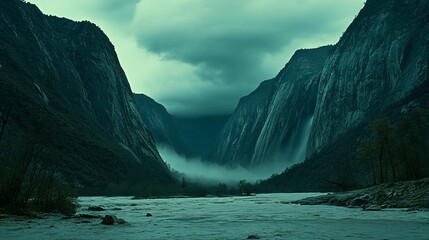 Fototapeta premium Misty mountain gorge with rushing river and waterfalls