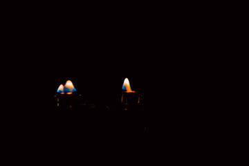Lit and unlit candles in a candelabra against a dark background, evoking warmth and memory.