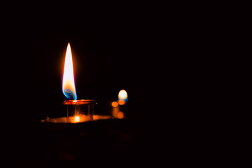 Lit and unlit candles in a candelabra against a dark background, evoking warmth and memory.