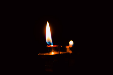 Lit and unlit candles in a candelabra against a dark background, evoking warmth and memory.