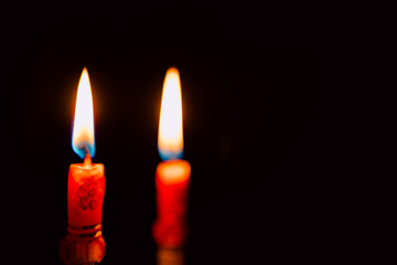 Lit and unlit candles in a candelabra against a dark background, evoking warmth and memory.