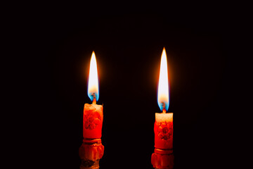 Lit and unlit candles in a candelabra against a dark background, evoking warmth and memory.