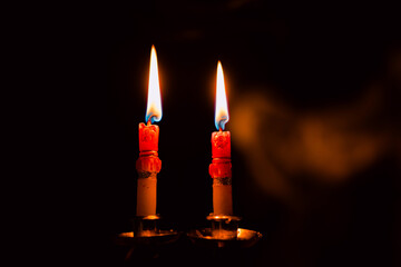 Lit and unlit candles in a candelabra against a dark background, evoking warmth and memory.