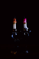 Lit and unlit candles in a candelabra against a dark background, evoking warmth and memory.