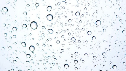 Abstract raindrops on a window glass creating a unique and textured background perfect for diverse design projects conveying freshness and clarity