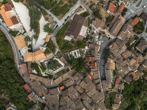 Fototapeta Aerial view of terracotta rooftops create a warm mosaic, nestled amongst the verdant hills, a serene portrait of Italian heritage, Anversa degli Abruzzi, Abruzzo, Italy.