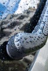Car wiper, raindrops and reflection of a building in the glass