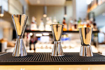 A set of shinny stainless steel jigger with multiple sizes on bar counter