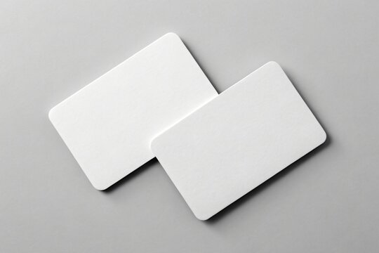 Two blank white rounded corner cards on gray surface