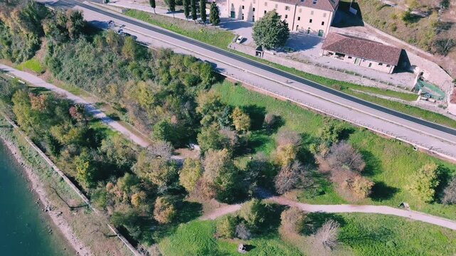 Drone flying Over Rocca d'Anfo and Lake Idro on a sunny day on a forested mountainside in Italy