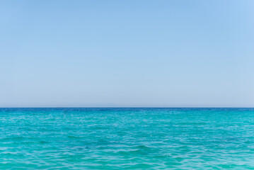 Calm turquoise sea meeting clear blue sky on the horizon, ideal for travel, summer, and relaxation...