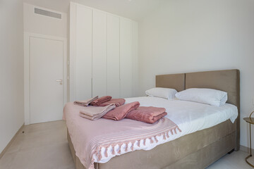 Bright Bedroom with Towels on Bed
