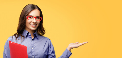 Image of smiling businesswoman in eyewear glasses with red folder, holding or giving something....