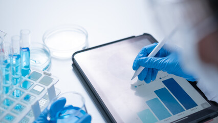 Professional scientist working writing experiment research results on tablet document for data analysis chemist hospital new discovery in genetic future planning innovation biotechnology chemical