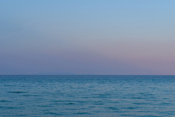 Obraz premium Open sea under blue twilight sky with faint distant horizon