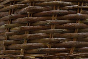 Close view of a handcrafted basket reveals the intricate weaving technique. The warm, natural tones of the materials highlight the craftsmanship and attention to detail.