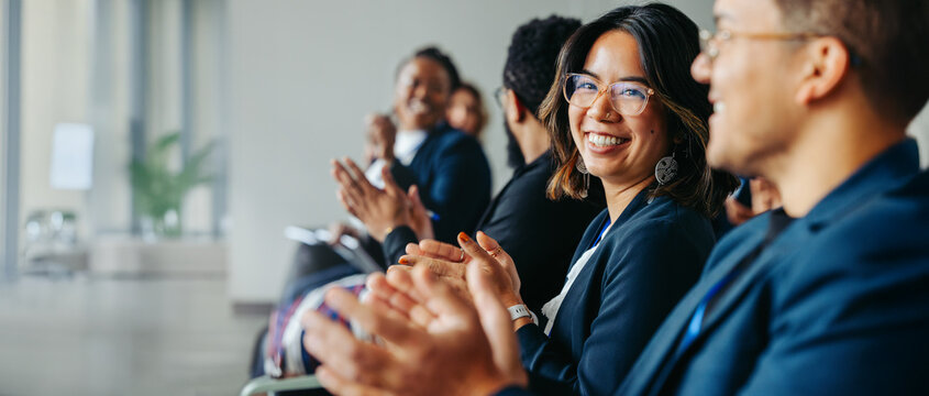 Diverse professionals applauding at corporate conference